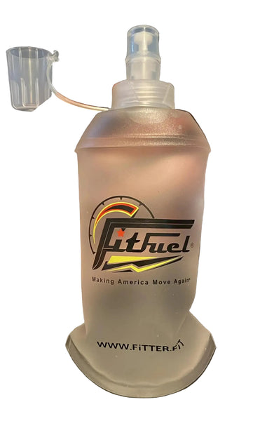 Clear plastic bottle with a spray top held by a hand against a black background