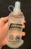 Clear spray bottle held in a hand with 'Fitter' branding on a black background